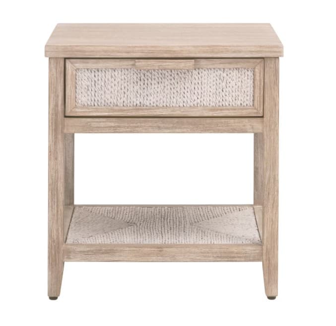 A light-colored wooden nightstand with a drawer and an open shelf. The drawer front and the shelf insert feature a woven texture. The overall design is simple and modern with tapered legs. — 3D model