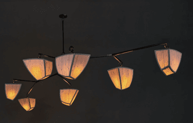 A modern, sculptural chandelier with a dark-finished metal frame and multiple articulated arms, each supporting an opaque, geometric white shade. The design is contemporary and minimalist, spreading light across a wide area. — 3D model