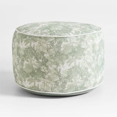 A fully upholstered, cylindrical ottoman featuring a light green and white fabric with an intricate aquatic or coral-themed pattern. It is defined by crisp white piping along its top and bottom circular edges, providing a tailored finish to its cushioned form. — 3D model