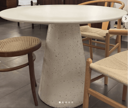 A light grey, round pedestal table with a conical base and a speckled concrete-like finish. — 3D model