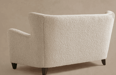 A contemporary two-seater loveseat upholstered in a cream-colored bouclé fabric. It features a high backrest that gently flares outwards at the top, integrated rolled armrests, and a seamless, fully upholstered form. The loveseat is supported by four short, dark, tapered wooden legs. — 3D model