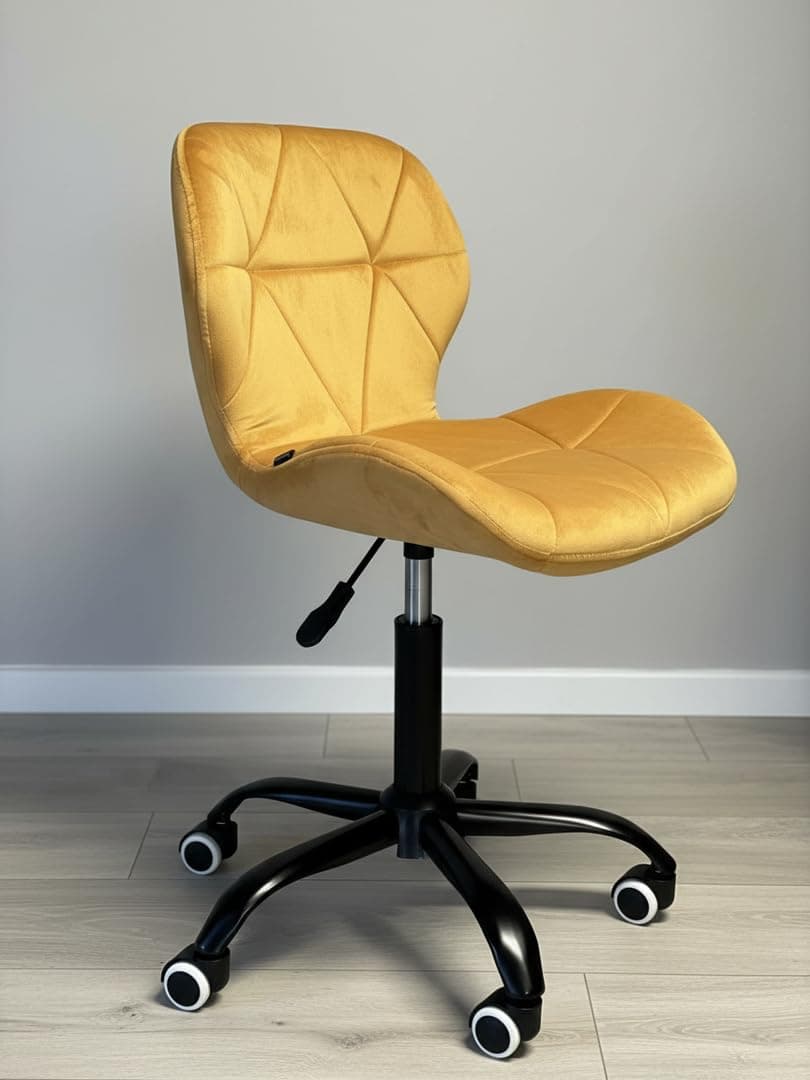 An armless office or task chair featuring a contoured seat and backrest upholstered in golden yellow velvet. The backrest and seat exhibit a distinctive geometric quilted pattern. The chair is supported by a black five-star base equipped with black and white casters for mobility. A visible lever indicates height adjustment functionality via a gas lift mechanism. The chair's design suggests a modern or contemporary aesthetic. — 3D model