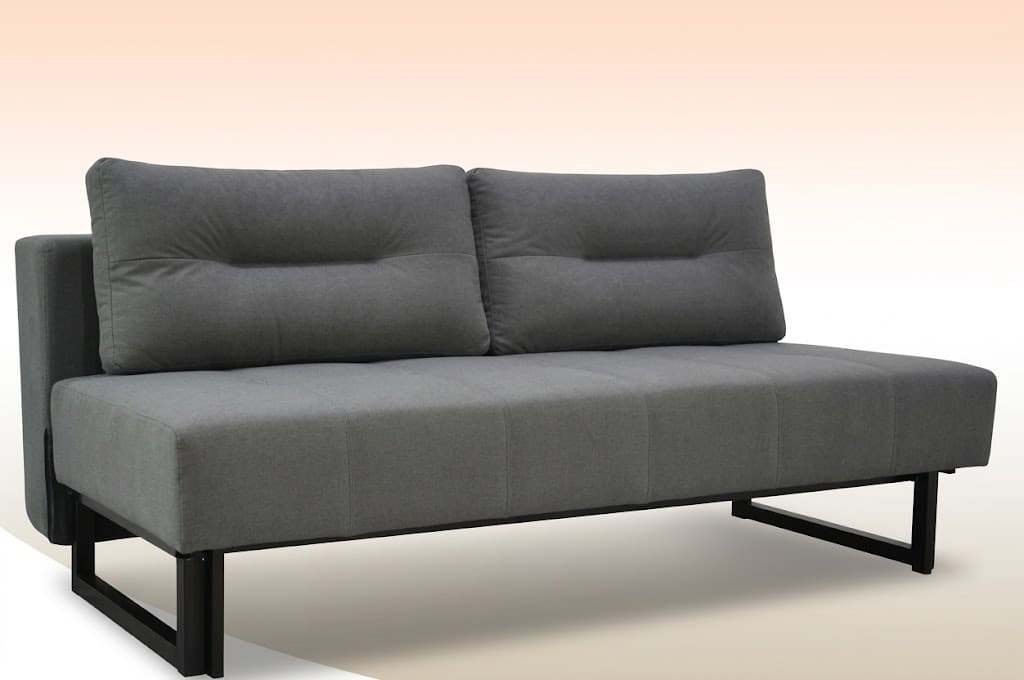 A modern futon sofa upholstered in a grey fabric, featuring a minimalist design with a low-profile silhouette. The sofa has two segmented seat cushions and two horizontally tufted back cushions. It rests on a black square-profile metal base, which forms integrated legs. The armrests are narrow, flat, and upholstered sections on the sides. — 3D model