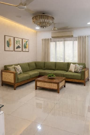 An L-shaped sectional sofa with a modern aesthetic, featuring an exposed light wood frame with cane webbing details on the back and sides. It is upholstered with olive green fabric cushions for both seating and backrests, and includes several decorative throw pillows. The sofa has a low-profile design and consists of multiple modular units forming a corner arrangement. — 3D model