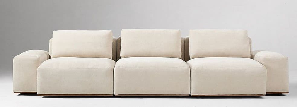 A modular sofa with three distinct seating sections. Each section features a plush, upholstered seat cushion and a separate, upright back cushion. The sofa has a low profile with thick, upholstered armrests that blend seamlessly into the seat base. A thin, dark wooden plinth base is visible underneath the entire unit. — 3D model