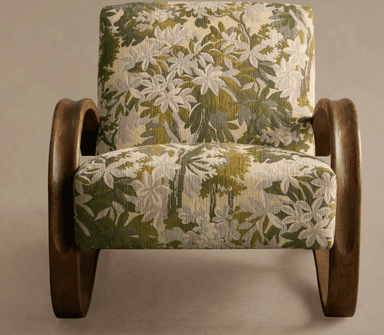 A vintage armchair featuring a high-backed design with curved wooden armrests and a patterned upholstery. The base consists of curved wooden legs that extend from the armrest structure, creating a cantilevered effect. The upholstery is a tapestry-style fabric with a floral motif in shades of green, beige, and white. — 3D model