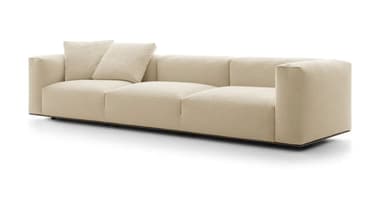 A contemporary three-seater sofa upholstered in a cream-colored boucle fabric. It features a low-profile design with three distinct seat cushions and two loose back cushions, along with wide, block-style arms. The sofa rests on discreet, low-set dark feet. — 3D model