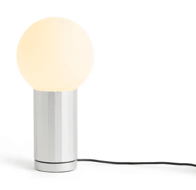 A modern table lamp featuring a spherical, frosted glass diffuser atop a cylindrical base with vertical fluting. The base is light-colored, possibly silver or white, and a black power cord extends from its bottom. The lamp is illuminated, emitting a soft, diffuse light. — 3D model