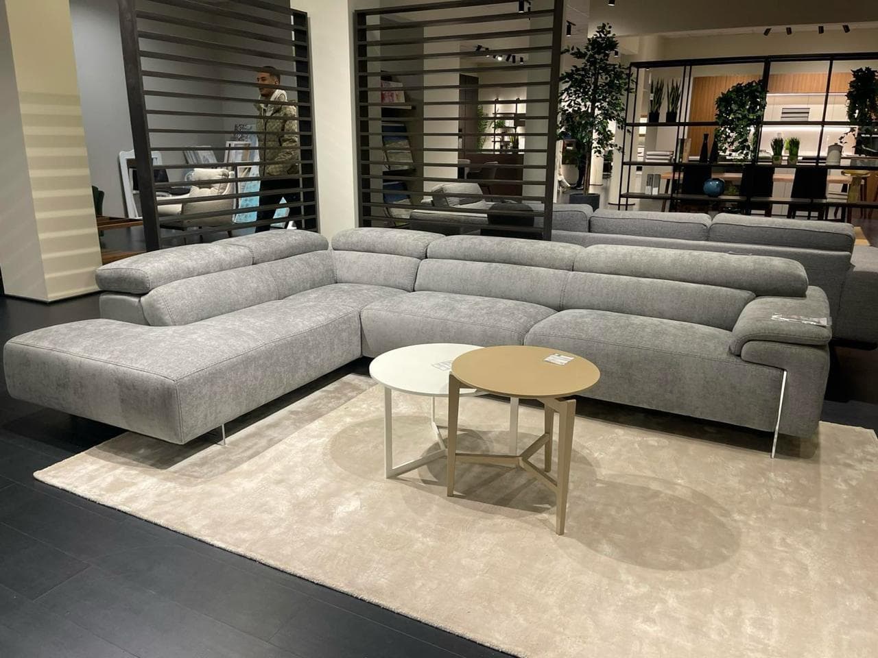 A modern sectional sofa with a chaise lounge extension. The sofa features multiple seating modules and adjustable headrests. It is upholstered in a textured grey fabric and supported by sleek metal legs. — 3D model