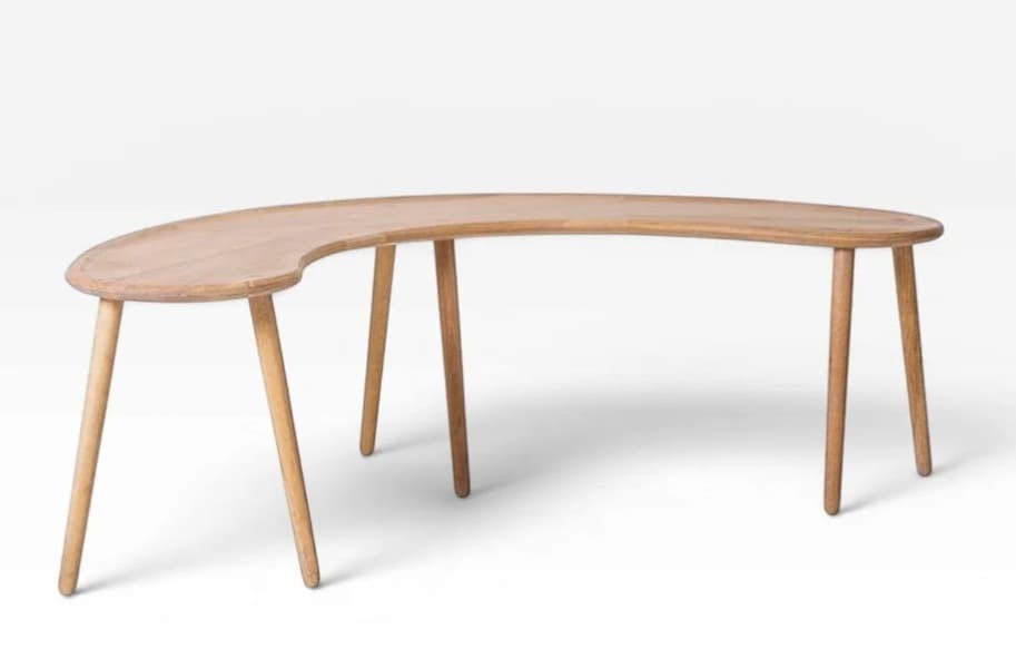 A light-toned wooden coffee table featuring a distinct crescent or bean-shaped top supported by multiple tapered, splayed wooden legs. The design is simple and organic, emphasizing the natural wood grain and smooth curves. — 3D model