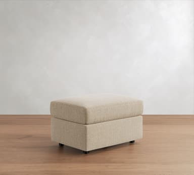 A modern, rectangular upholstered ottoman with a plush top cushion and a slightly recessed base, all covered in a light beige, textured fabric, resting on small dark feet. — 3D model
