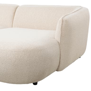 A modular sectional sofa with a curved, organic design. It features a plush, textured upholstery in a light cream or off-white color and sits on small, dark metal legs. The sofa appears to be composed of at least two sections, one with an extended chaise lounge. — 3D model