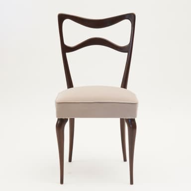 A side chair with a curved, open backrest and a padded seat. The frame and legs are made of dark wood, with a sculpted, organic form. The seat is upholstered in a light-colored fabric. — 3D model