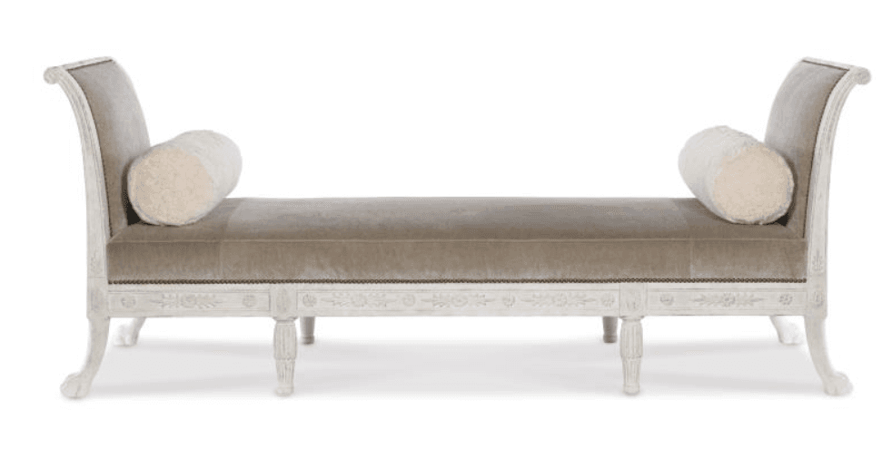 A chaise lounge with a curved backrest and armrests that transition into the back. It features a long upholstered seat and is supported by four ornate legs. Two cylindrical bolster pillows are placed on the seat. The frame is finished in a distressed white paint with decorative carvings. — 3D model