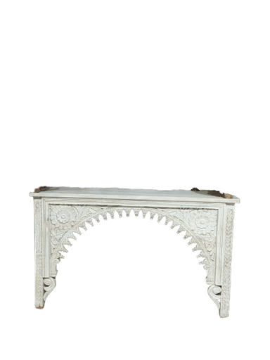A long, narrow console table, painted white, featuring intricate hand-carved floral and architectural motifs, most notably a central arched design with scalloped edges. It has a flat rectangular top and two front legs supporting the heavily carved facade. — 3D model