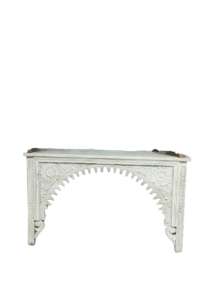 A long, narrow console table, painted white, featuring intricate hand-carved floral and architectural motifs, most notably a central arched design with scalloped edges. It has a flat rectangular top and two front legs supporting the heavily carved facade. — 3D model