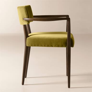 A wooden armchair with upholstered seat and back. The frame is constructed from dark wood with visible grain. The seat and back are upholstered in a textured, mustard-yellow velvet fabric. The upholstery on the seat is secured with a row of decorative brass tacks around its perimeter. The armrests are integrated into the wooden frame and extend from the backrest support to the front legs. — 3D model