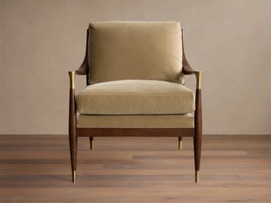 A plush armchair with a wooden frame and velvet upholstery. The armchair features a high back and seat cushions, with elegantly curved wooden arms. Decorative brass accents are present on the armrests and the tapered legs, which are capped with brass. — 3D model