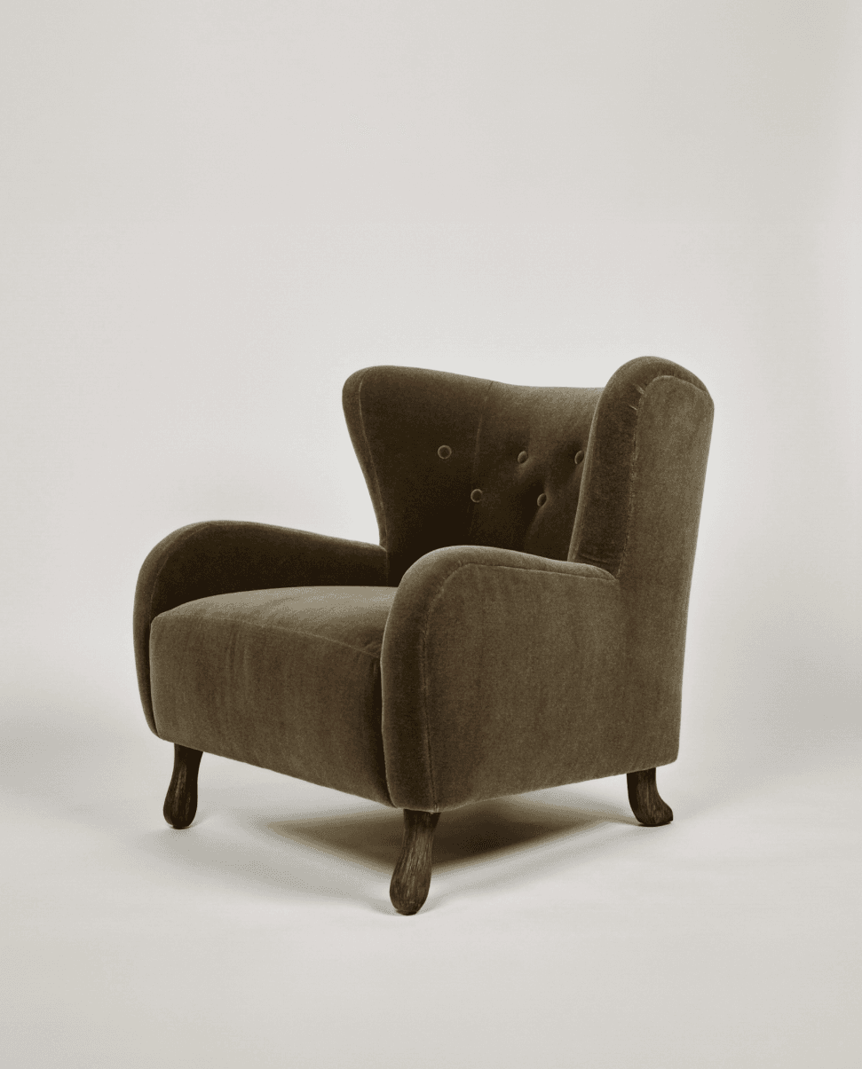 A high-backed upholstered lounge chair in a deep olive green velvet-like fabric, featuring button tufting on the backrest, rounded armrests, and short, splayed dark wood legs. — 3D model