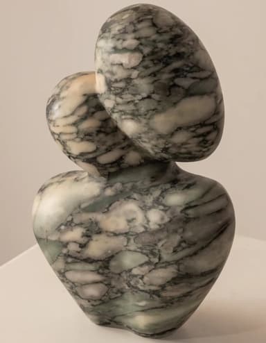 An abstract, biomorphic sculpture made from veined marble. The piece features a curvilinear, organic form with a wider base tapering up to two rounded, interlocking shapes at the top. The marble exhibits natural patterns of green, grey, and white veining, and the entire surface is highly polished. — 3D model