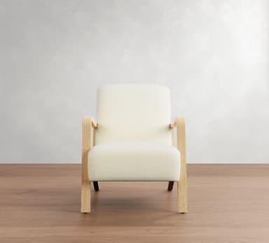 A modern armchair with a light-colored upholstered seat, back, and armrests, supported by a light wood frame. The frame consists of four legs, with the front legs extending upwards to form the armrests, and a connecting horizontal piece. — 3D model