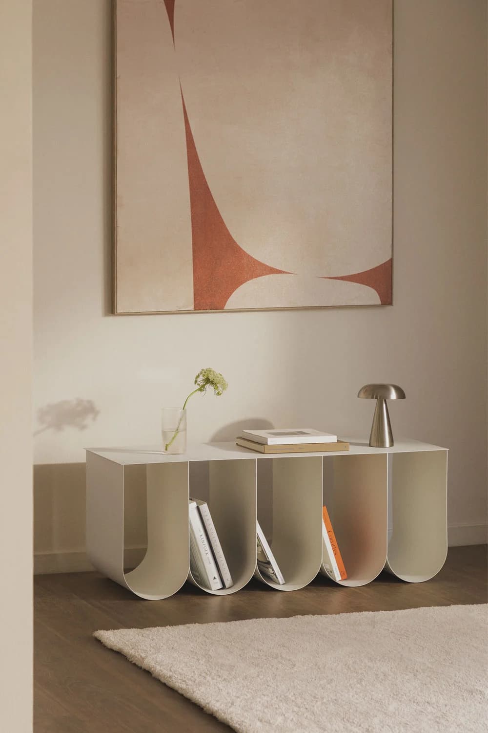 A minimalist, wall-mounted shelf unit with five open compartments. The unit has a clean, rectangular top surface and front face, with each compartment featuring a rounded, U-shaped opening at the bottom. The design is simple and modern, emphasizing vertical storage. — 3D model