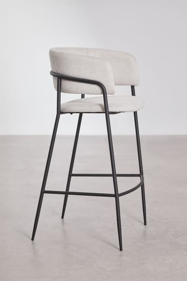 A modern bar stool featuring a light gray upholstered seat and a wraparound backrest that seamlessly integrates armrests. The seat and back are cushioned, providing comfort. The entire upholstered section is supported by a slender black metal frame which forms the four legs, reinforced by a circular footrest at the bottom. The design is minimalist and contemporary. — 3D model