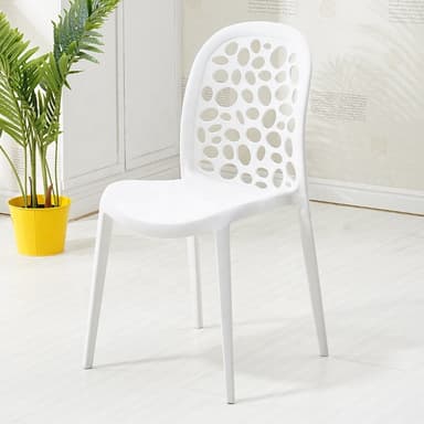 A modern white armless chair made of molded plastic, featuring a distinctive backrest with irregular perforated cutouts and four tapered legs. — 3D model