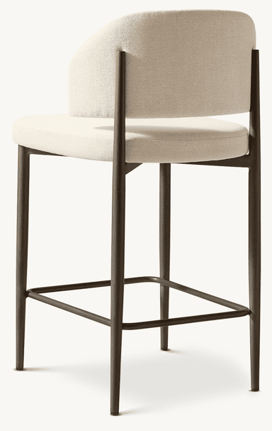 A contemporary bar stool featuring a light beige upholstered seat and a gently curved backrest, supported by a bronze-finished metal frame with an integrated square footrest. — 3D model