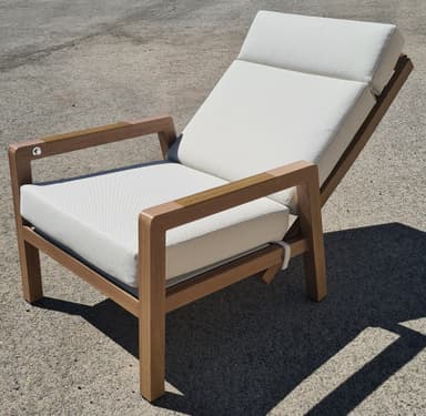 A lounge chair with a wooden frame and white upholstered cushions. The chair features adjustable backrest and armrests. The wooden frame has a natural finish, and the cushions are made of a textured fabric. Straps are visible to secure the cushions. — 3D model