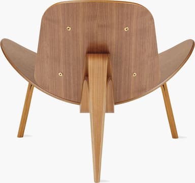 A high-quality image of a Hans J. Wegner CH07 Shell Chair, featuring a distinctive three-legged, curved plywood frame with black leather upholstered seat and back pads. The chair exhibits a light wood finish and a sleek, sculptural form against a white background. — 3D model