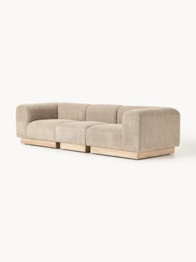 A modular upholstered bench consisting of three individual, backless sections. Each section is covered in a textured, light beige fabric and sits upon a recessed base made of light-toned wood. The design is contemporary and minimalist, emphasizing clean lines and a low profile. — 3D model