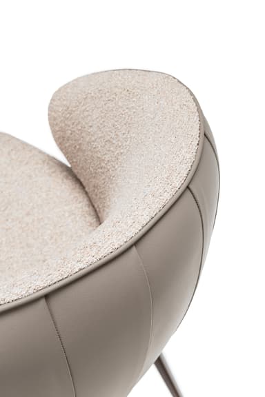 A modern armchair with a curved back and seat, upholstered in textured beige fabric and smooth taupe leather. It features a swivel base supported by four slender, angled legs in a dark metallic finish. — 3D model