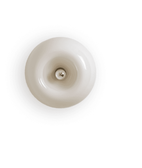 A minimalist wall sconce featuring a circular, donut-shaped body with a glossy, cream-colored finish. The center of the fixture is concave, leading to a small, polished spherical metallic element positioned at its deepest point. The design suggests a flush-mount installation, providing a sleek and integrated look. The material appears to be a type of ceramic or opaque glass, lending a smooth, uniform surface to the piece. — 3D model