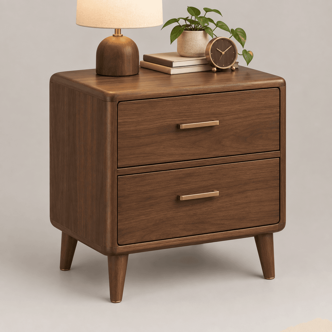 A compact mid-century modern nightstand crafted from dark walnut wood, featuring two spacious drawers with minimalist brass bar pulls. The design includes elegantly rounded corners on the top and sides, and four slender, tapered legs that splay slightly outward, contributing to its iconic aesthetic. The wood grain is visible, adding natural texture to its smooth, polished finish. — 3D model