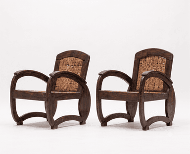 A dark-stained wooden armchair featuring a sturdy frame with curved armrests and legs, and intricately woven cane for both the seat and the backrest. The design suggests a classic, possibly colonial or tropical aesthetic. — 3D model