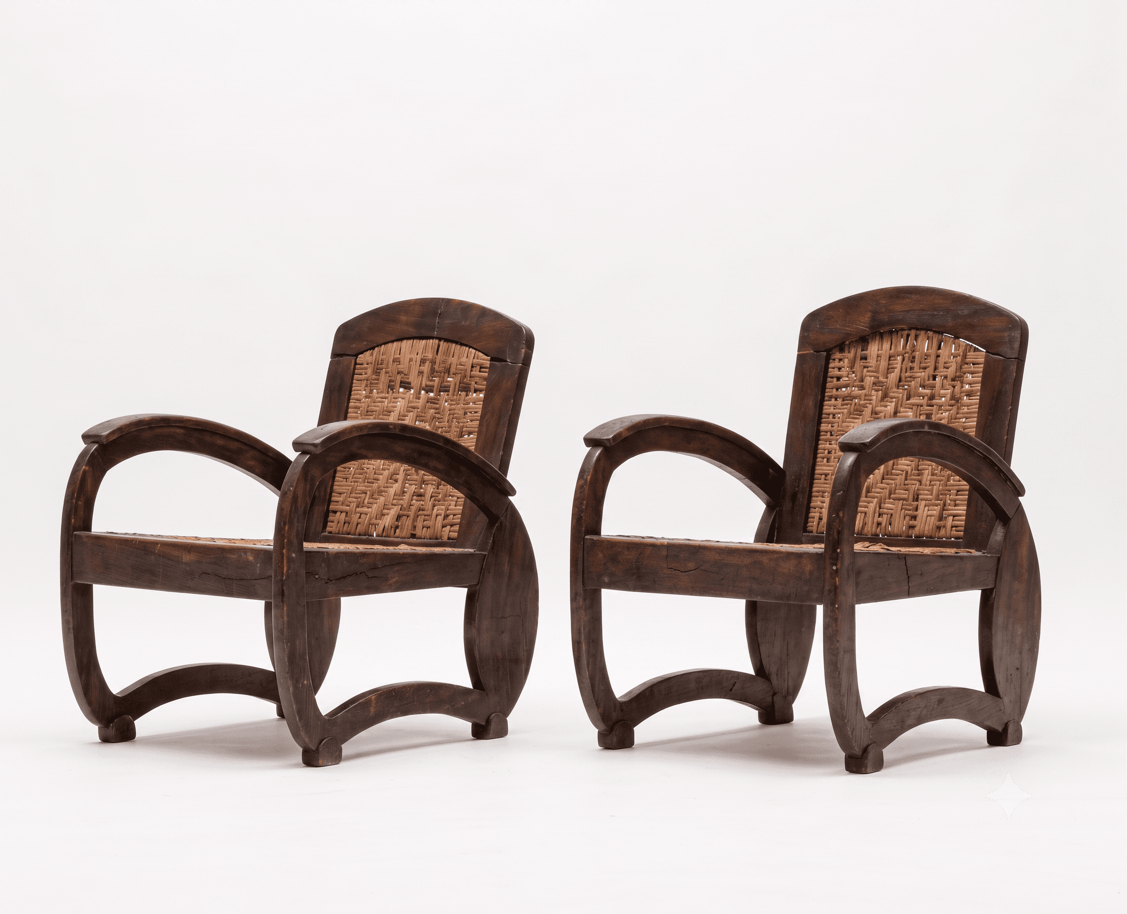 A dark-stained wooden armchair featuring a sturdy frame with curved armrests and legs, and intricately woven cane for both the seat and the backrest. The design suggests a classic, possibly colonial or tropical aesthetic. — 3D model