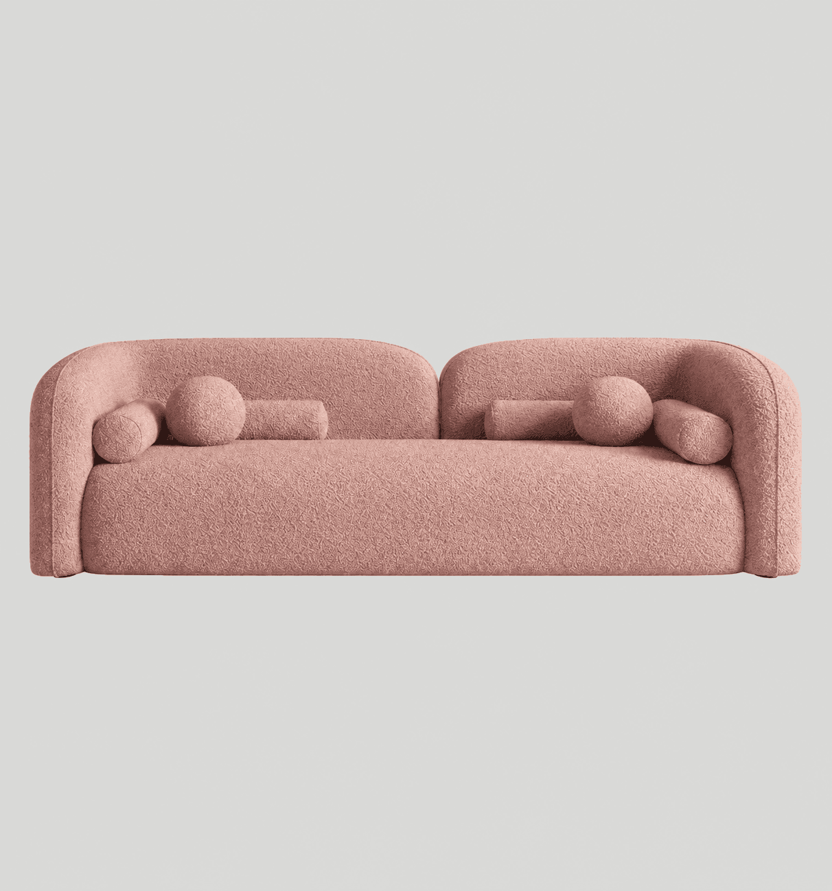 A contemporary, three-seater sofa characterized by its curvilinear form and plush bouclé upholstery. It features low, continuously rounded armrests and backrest, creating a seamless, sculptural silhouette. The sofa is finished in a light pink bouclé fabric and includes two cylindrical bolster pillows and one spherical accent pillow, all upholstered in the same material. — 3D model