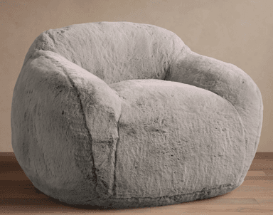 A plush, light gray faux fur lounge chair with a rounded and inviting silhouette. The chair features integrated, soft armrests and a contoured back, entirely covered in a shaggy, soft material. It appears to be a soft-filled design, resting directly on the floor without visible legs. — 3D model