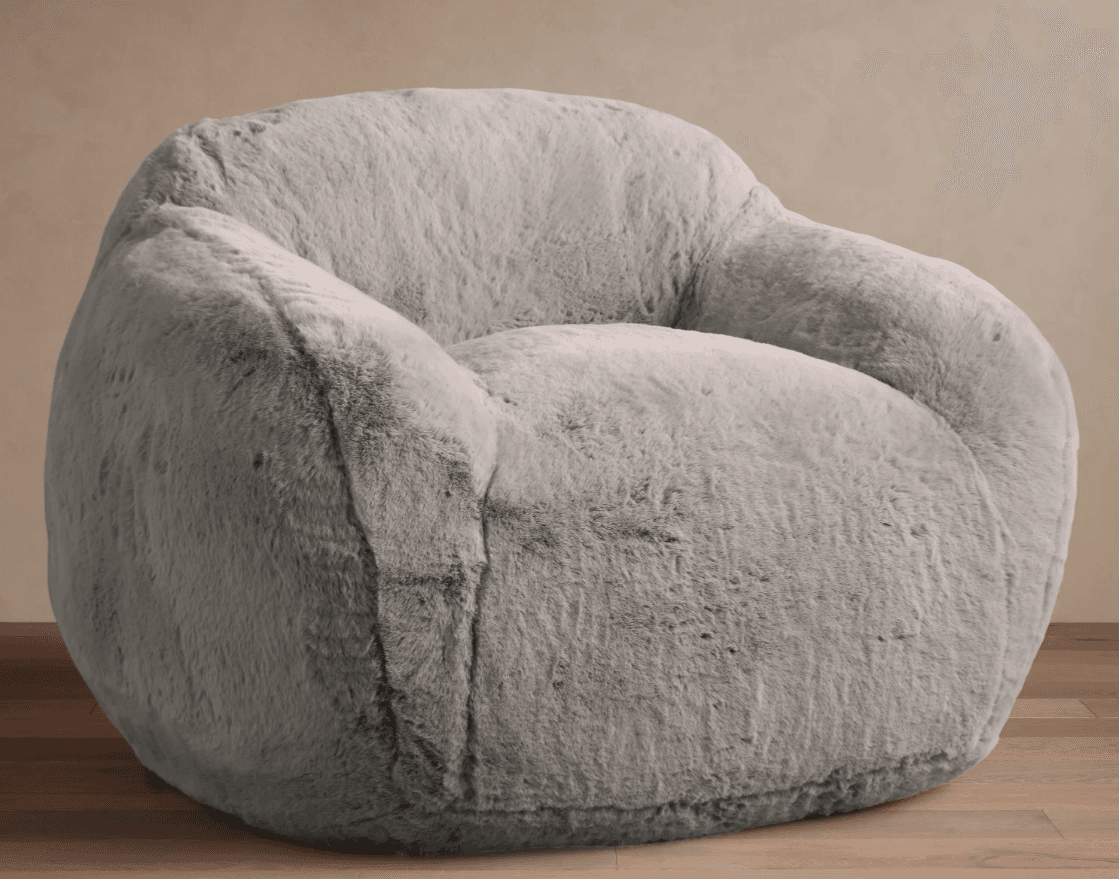 A plush, light gray faux fur lounge chair with a rounded and inviting silhouette. The chair features integrated, soft armrests and a contoured back, entirely covered in a shaggy, soft material. It appears to be a soft-filled design, resting directly on the floor without visible legs. — 3D model