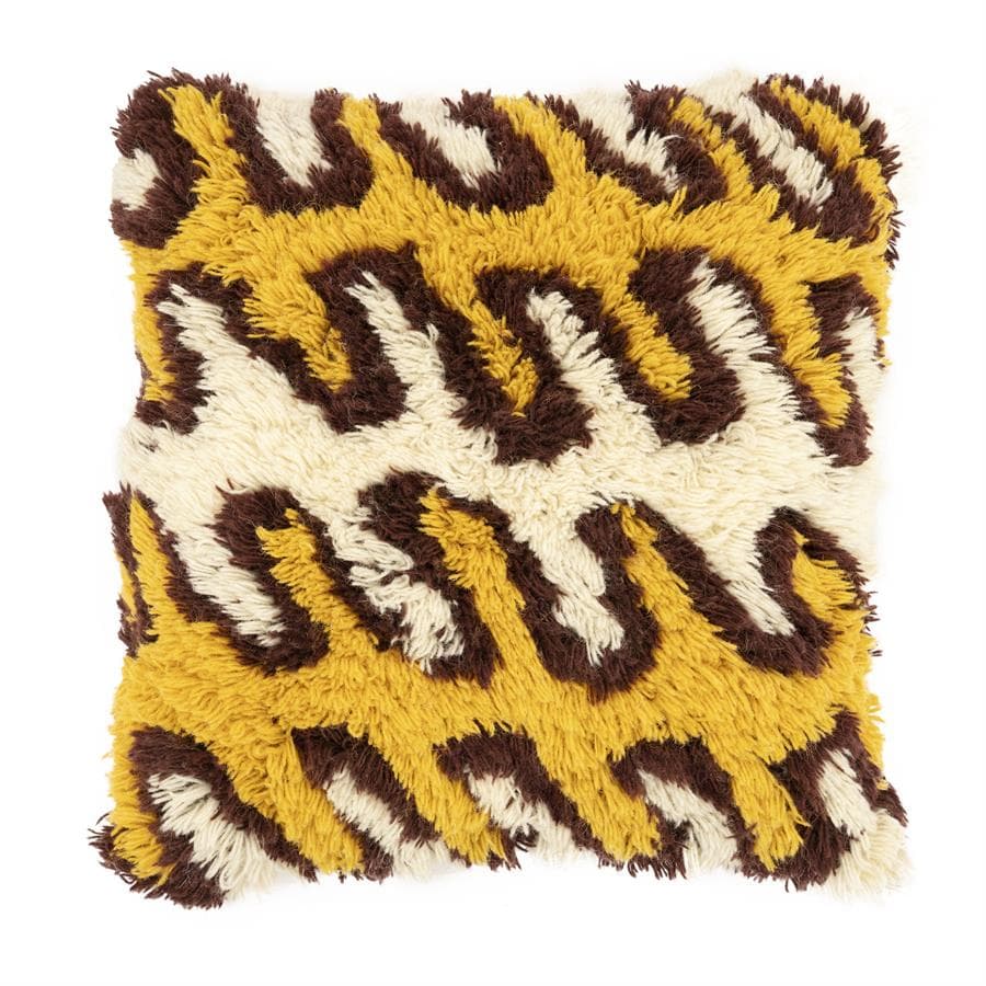 A decorative cushion with a plush, textured surface featuring a leopard print pattern. The pattern consists of irregular brown and yellow shapes against a cream background, created with shag-like fibers. The edges appear somewhat frayed or unfinished, indicating a handmade or rustic aesthetic. — 3D model