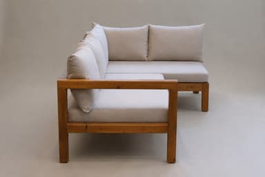 An L-shaped sectional sofa featuring an exposed wooden frame with square legs and armrests, paired with light-colored, plush fabric seat and back cushions. — 3D model