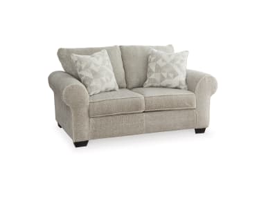 A light greige upholstered loveseat, viewed from the rear-side, featuring rolled arms and two plush back cushions, supported by low-profile dark feet. — 3D model