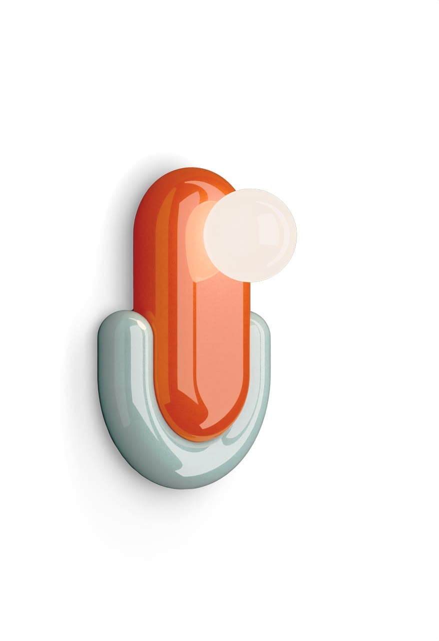 A modern wall sconce featuring a glossy, two-toned capsule-shaped body. The primary vertical element is a vibrant orange, while a U-shaped base in light blue cradles the bottom. A spherical, frosted white diffuser for the light source protrudes from the upper orange capsule. The overall design is minimalist and geometric, providing a decorative and functional lighting solution. — 3D model