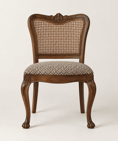 A traditional dining chair with a dark wood frame, featuring a woven cane backrest and an upholstered seat with a geometric pattern. The chair exhibits ornate carvings on its curved back, apron, and cabriole legs, which terminate in stylized claw feet. — 3D model