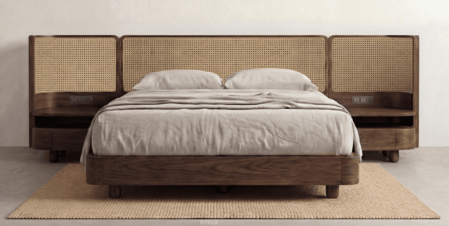 A modern platform bed featuring a dark wood frame with rounded edges and a prominent headboard constructed from multiple cane panels. The headboard design includes integrated floating nightstands on either side, which also have rounded forms and a single drawer. The bed is depicted with light-colored bedding, complementing the natural cane and dark wood. — 3D model