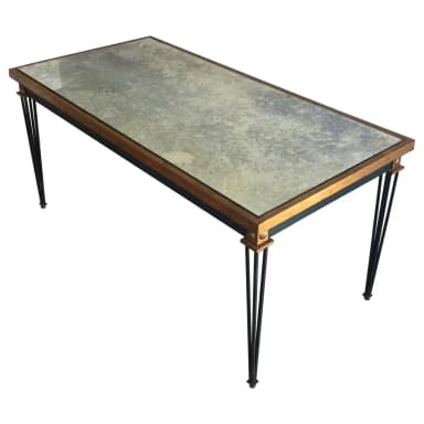 A rectangular coffee table featuring an antiqued, mottled mirror top set within a slender, gilded metal frame. The table stands on four clusters of splayed, thin black metal legs that taper slightly, with small gilded decorative elements at the top connection points and at the feet. — 3D model