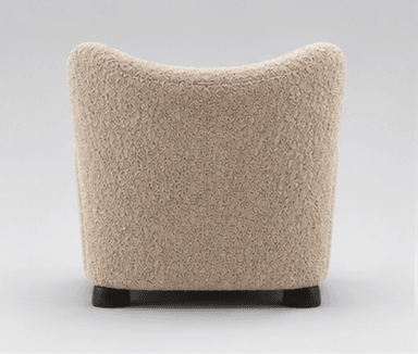 A modern upholstered armchair featuring a distinctive highly textured, beige fabric and a rounded, inviting silhouette, set on small, dark wooden feet. — 3D model