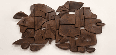 An abstract, wall-mounted sculpture composed of multiple interlocking segments of dark, richly grained wood. Each segment is uniquely carved with organic, fluid shapes and varying depths, creating a complex, three-dimensional relief. The pieces fit together to form a larger, irregular composition that evokes natural forms or a fragmented landscape. — 3D model