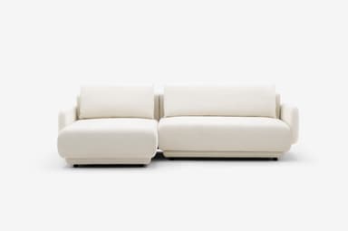 A modular sectional sofa with a chaise lounge extension. The sofa features a low-profile design with thick, upholstered cushions and rounded armrests. The frame appears to be upholstered in a textured fabric. — 3D model